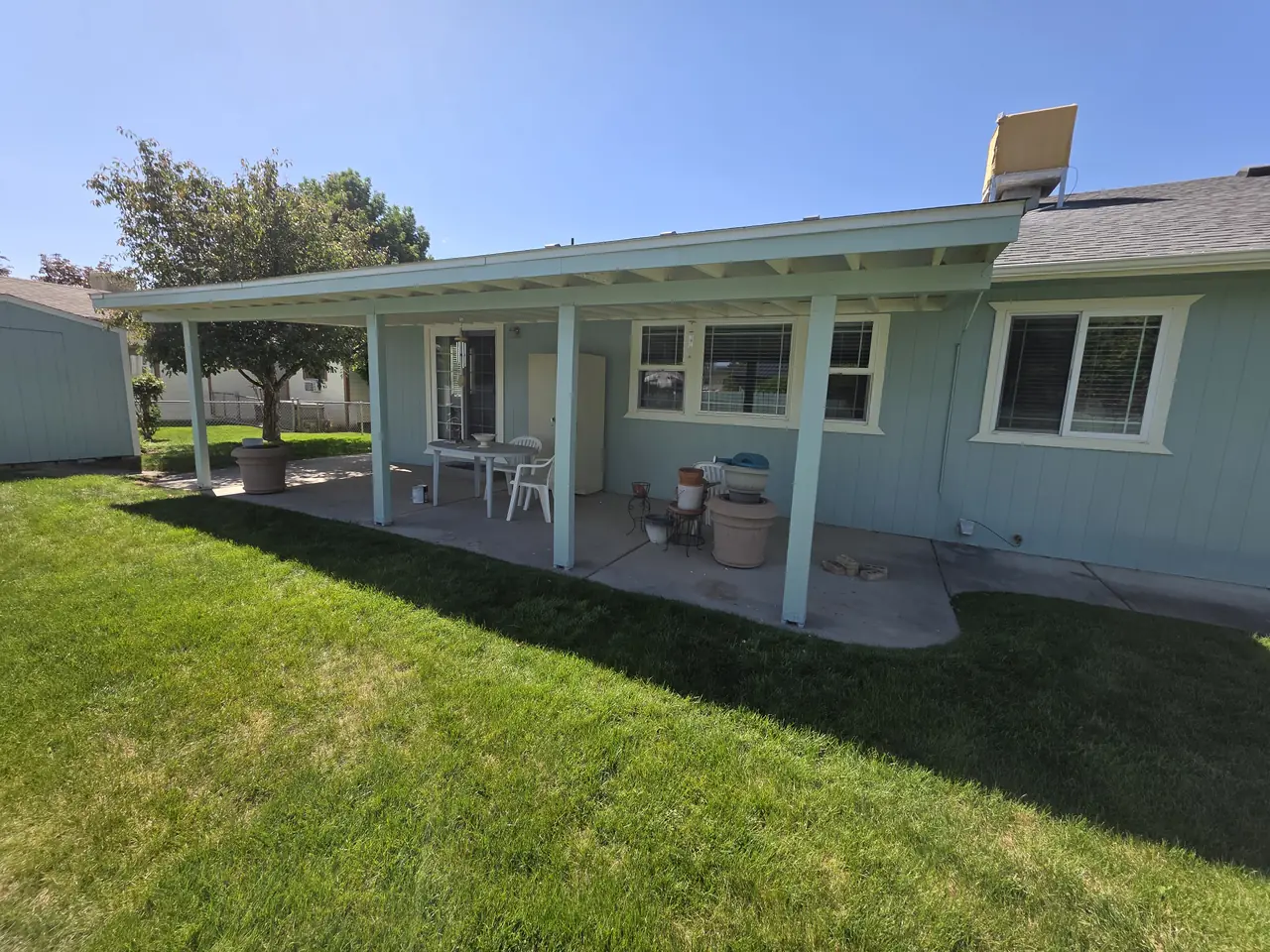 Light blue house exterior with crisp white trim and covered back patio