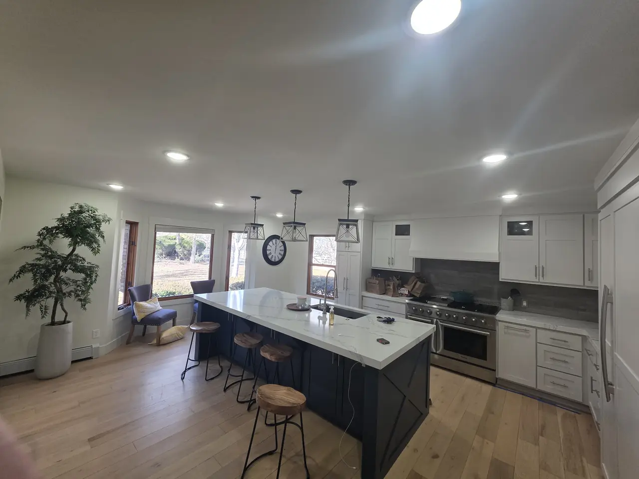 Kitchen with white perimeter cabinets and a navy island